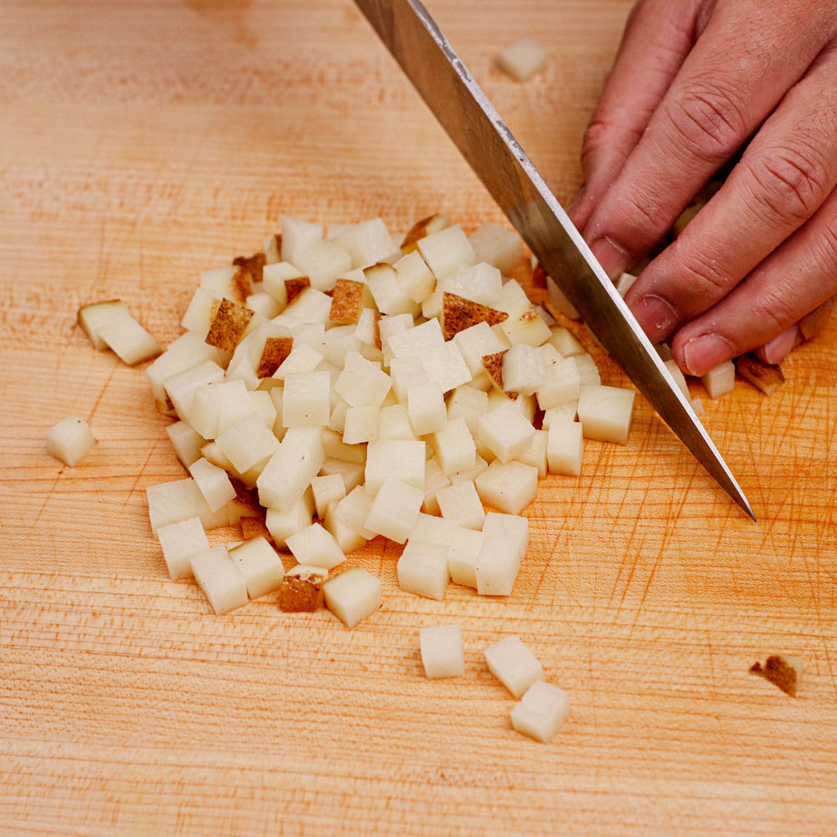 Dicing potatoes on a chopping board