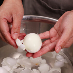 Peeling air fried hard boiled eggs in ice bath