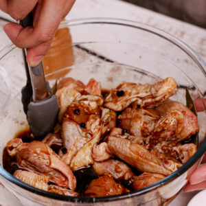 Seasoning wings with adobo marinade.