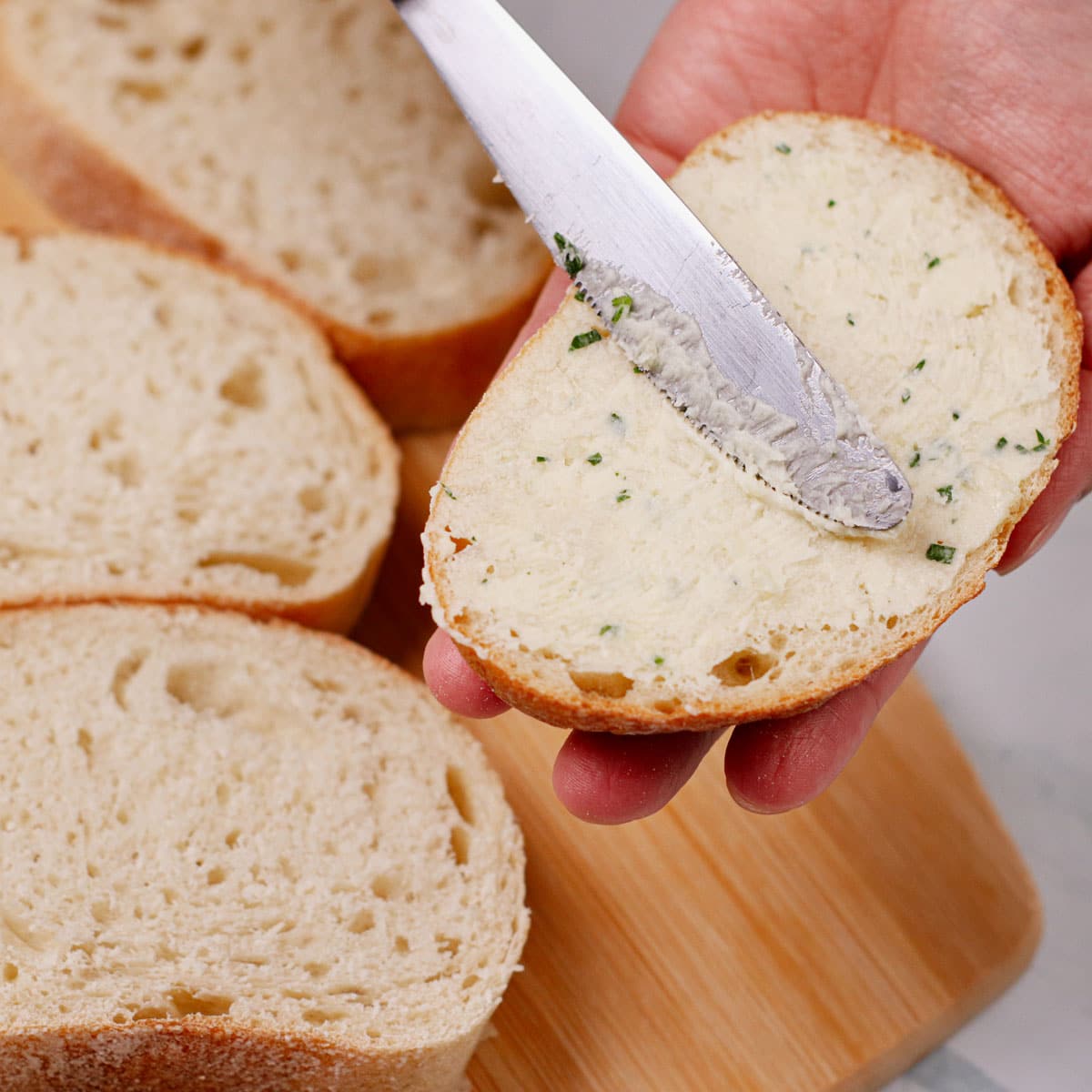 Spreading garlic butter on a bread slice