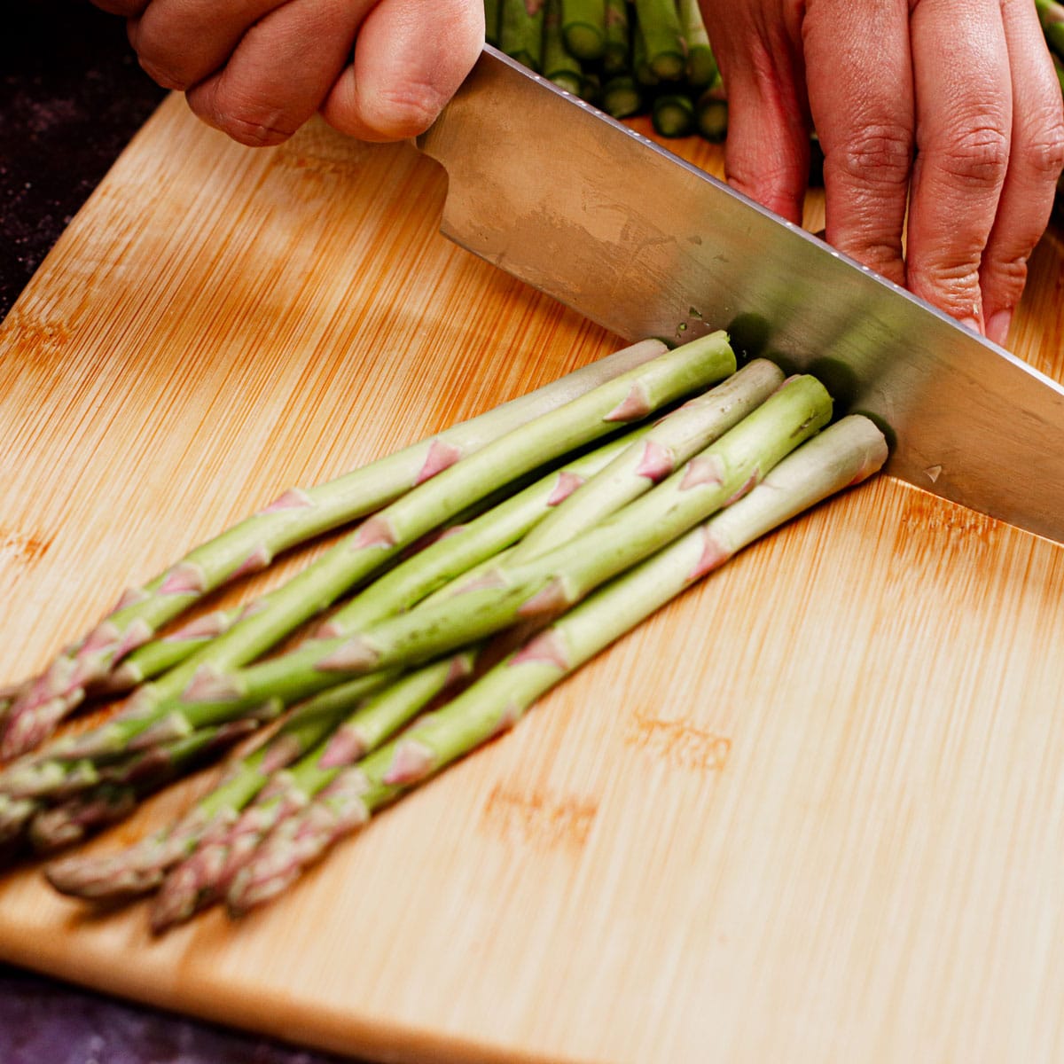 Trimming asparagus on a chopping board
