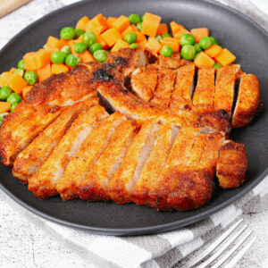 Air fried bone-in pork chops with peas and diced carrots.