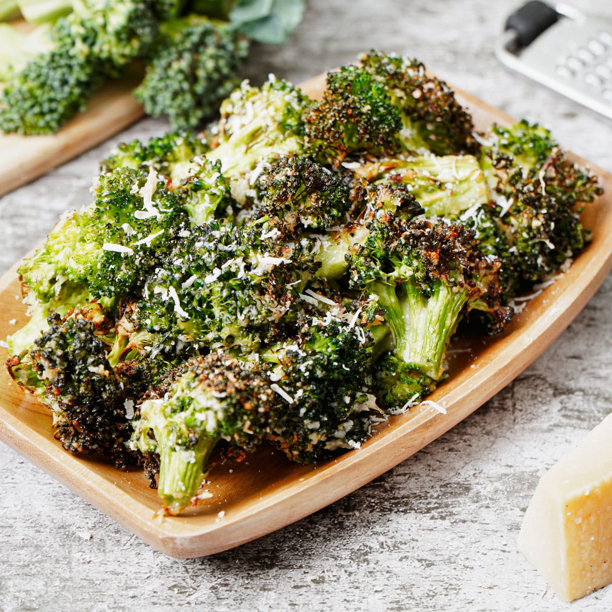 Air fried broccoli parmesan served in a wooden tray.