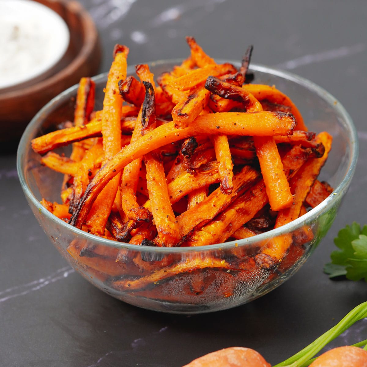 Air fried carrot fries in a medium glass bowl