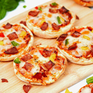 4 slices air fried English muffin pizzas on a bamboo chopping board