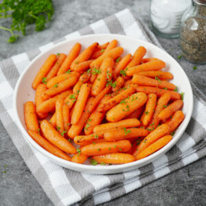 Roasted air fryer baby carrots with garnish of fresh parsley.