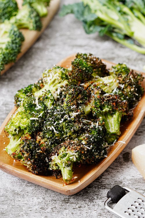 Air fryer broccoli parmesan recipe bite shot, served in a wooden tray.