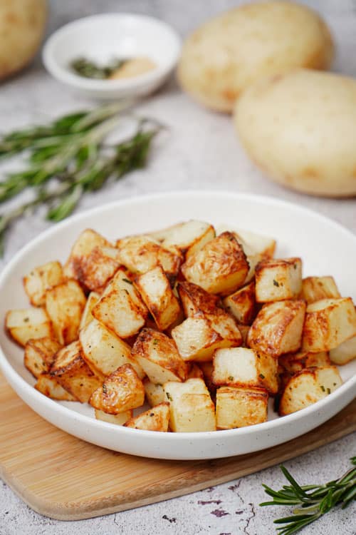 Air fryer diced potatoes recipe bite shot, served in a white salad plate