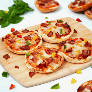 4 slices air fryer English muffin pizzas on a bamboo chopping board