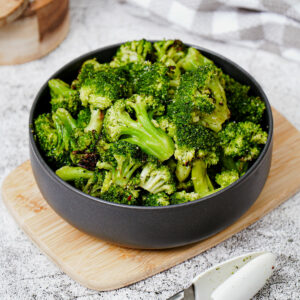 Roasted air fryer frozen broccoli in a black bowl.