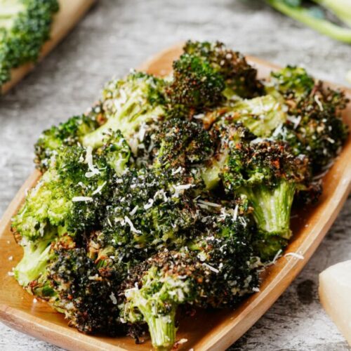 Air fryer broccoli parmesan recipe bite shot, served in a wooden tray.