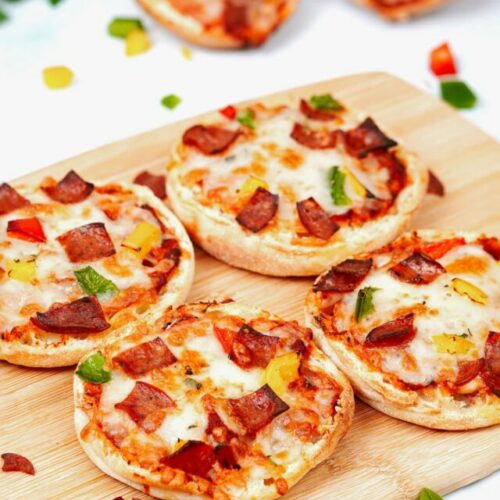 Air fryer English muffin pizza recibe bite shot, 4 slices on a bamboo chopping board.