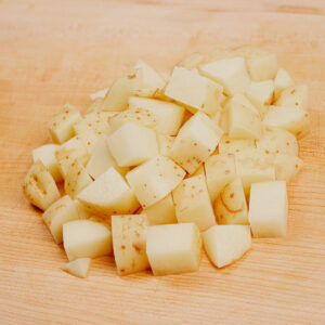 Potato cubes on a chopping board
