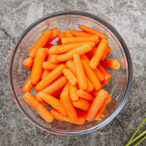 Baby carrots in a medium glass bowl