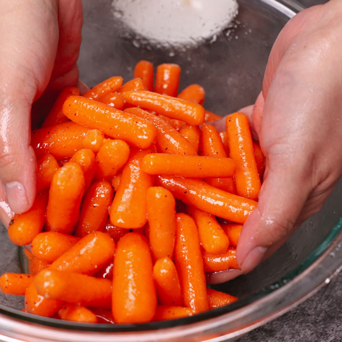 Seasoning baby carrots with avocado oil, salt, pepper, brown sugar