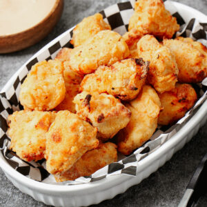 Air fried chicken nuggets in a medium baking dish with fry sauce.