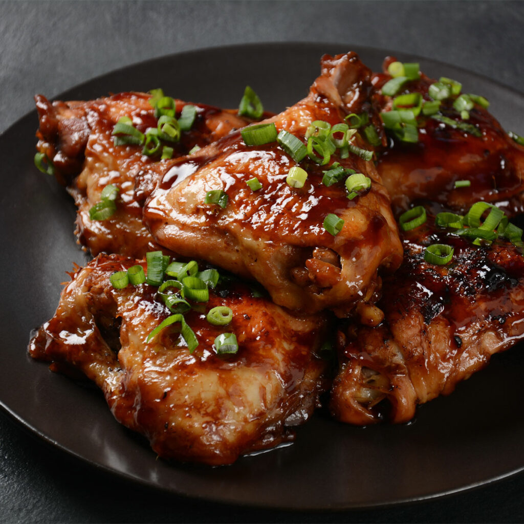 air fried marinated chicken thighs, garnished with scallions