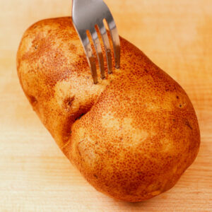 Pricking potato with fork to prevent steam from building up