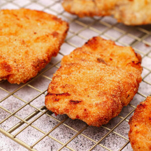 Air fried schnitzels on a cooling rack.