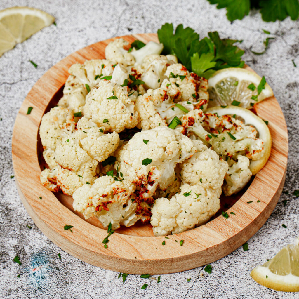 Roasted air fryer ranch parmesan cauliflower with lemon slices.