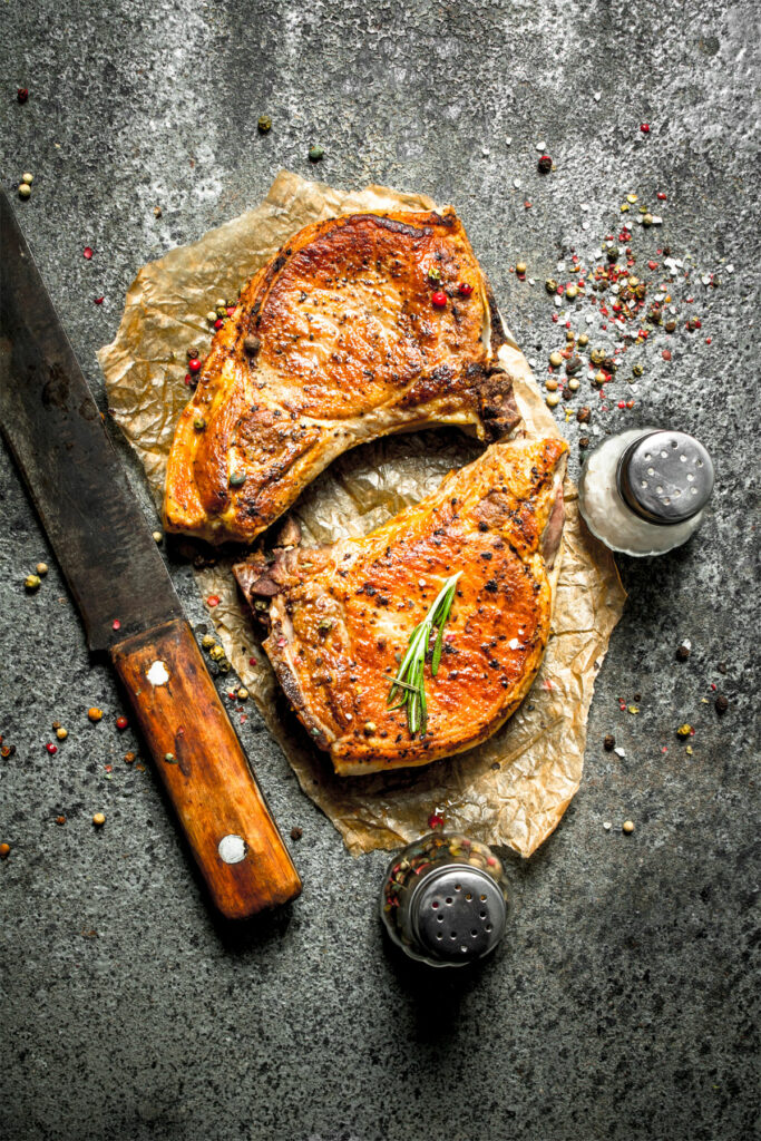 air fryer bone-in pork steak, recipe bite-shot, with knife on the side
