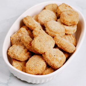 Uncooked frozen chicken nuggets on a medium-sized baking dish