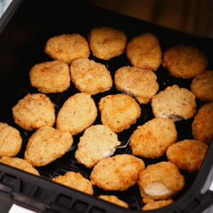 Frozen chicken nuggets in air fryer basket
