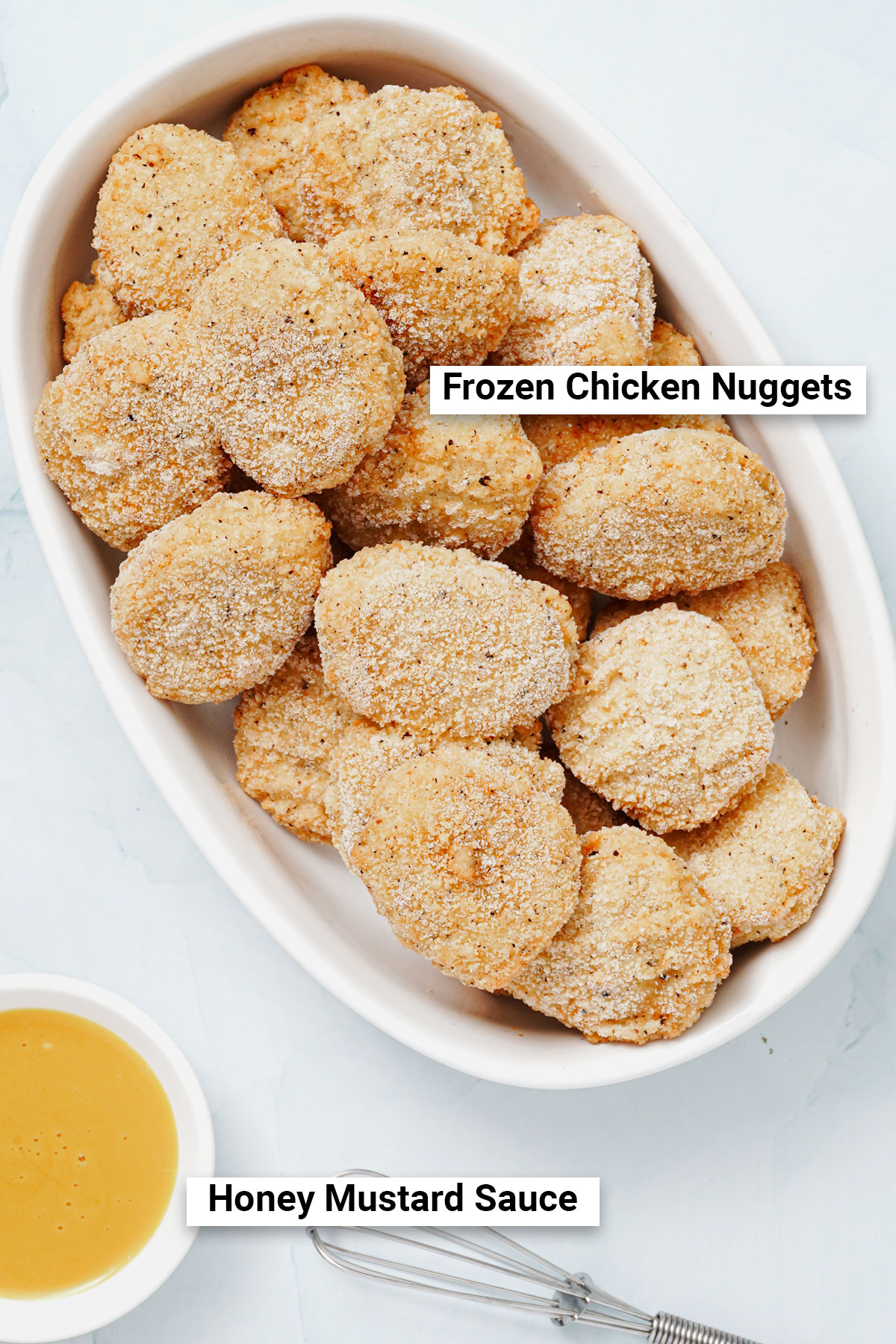 Uncooked frozen chicken nuggets with honey mustard dipping sauce, top view