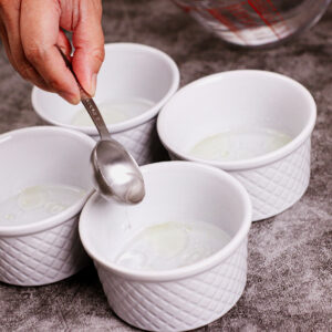 Adding oil and hot water to ramekin bowls