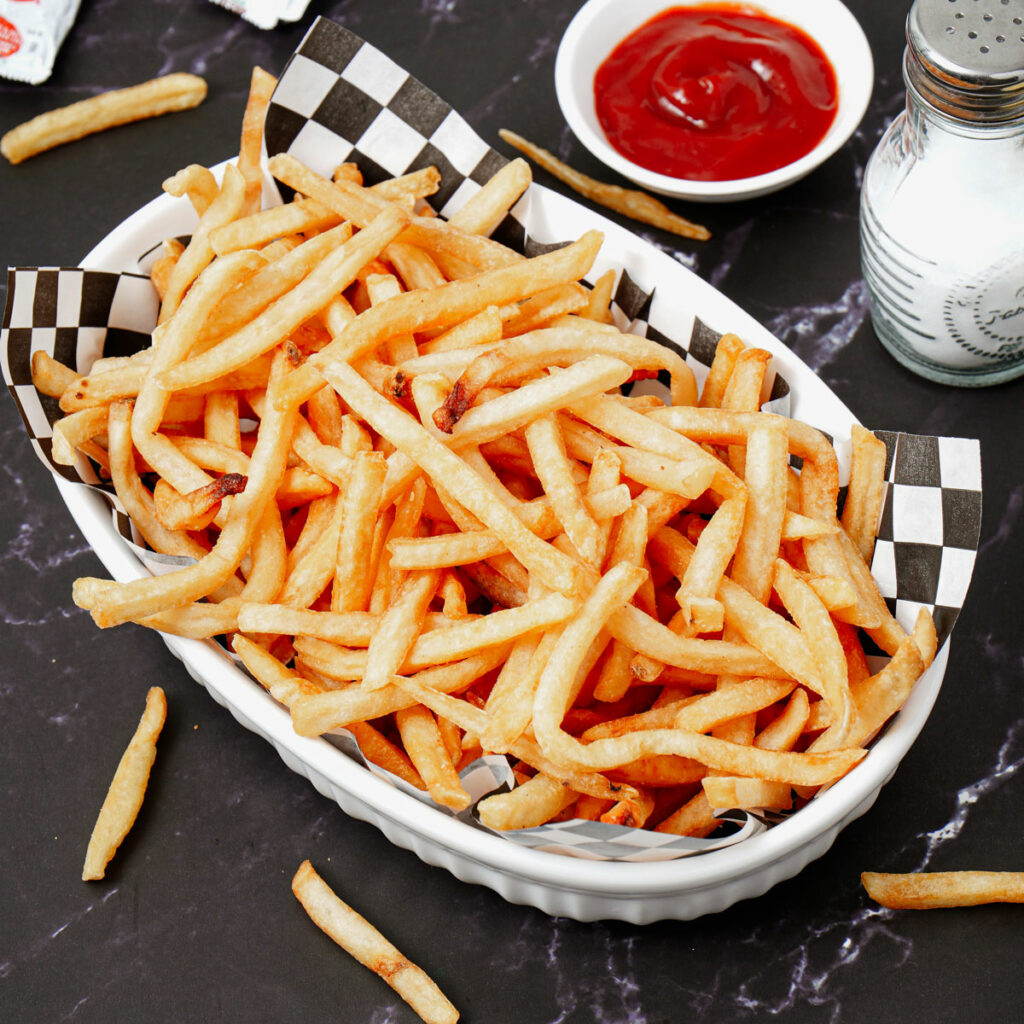 Air fryer reheated fries with ketchup and salt on the side.
